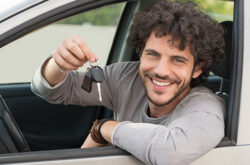 Portrait Of Young Happy Man Showing The Key Sitting In New Car Portrait Of Young Happy Man Showing The Key Sitting In New Car